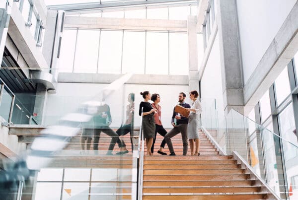 Review Our Agency - Group of Business People Standing in the Hallway Chatting